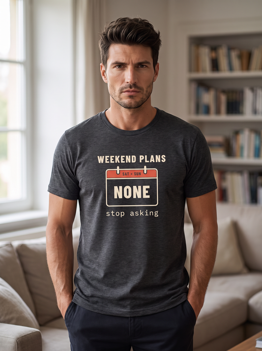 Liora wearing the unisex t-shirt in dark grey heather with a calendar page for Saturday and Sunday reading none and cream type reading weekend plans, stop asking. Model: Liora (AI brand character). AI-generated model image; the printed design is the actual product artwork.