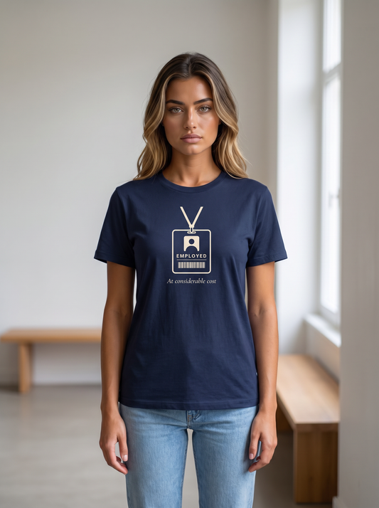 Seloura wearing the unisex t-shirt in navy with a drawing of a staff badge on a lanyard reading employed and serif type reading at considerable cost. Model: Seloura (AI brand character). AI-generated model image; the printed design is the actual product artwork.