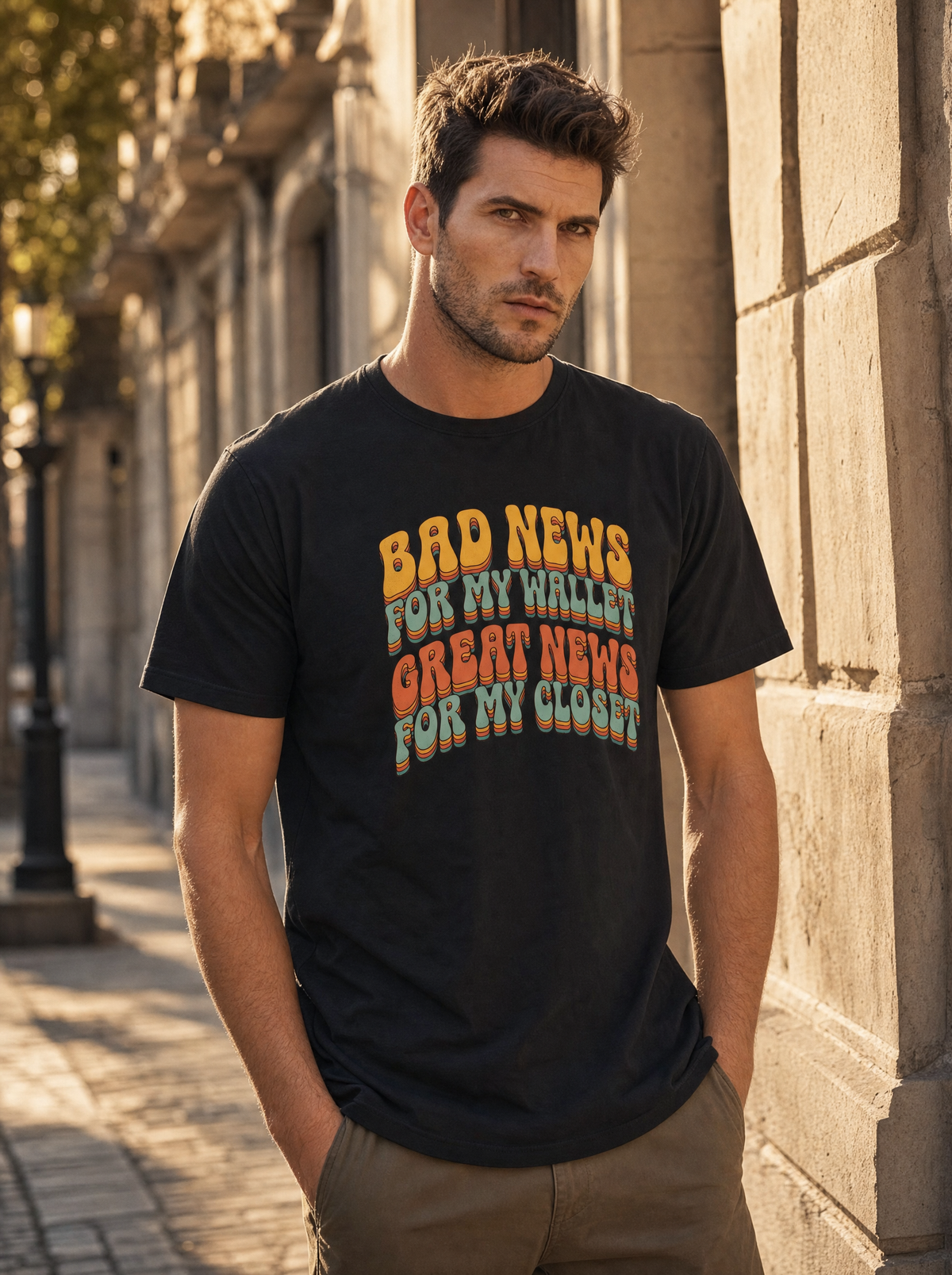Bad News for My Wallet retro 70s garment-dyed tee in black, worn on a city street by Liora, Printelier's male brand character. AI-generated model image; the printed design is the actual product artwork.