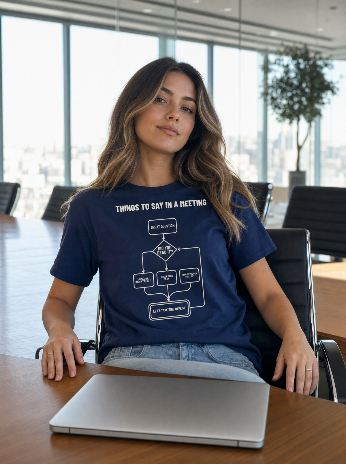 Things to Say in a Meeting flowchart tee in navy, worn at a conference table. Model: Seloura (AI brand character).