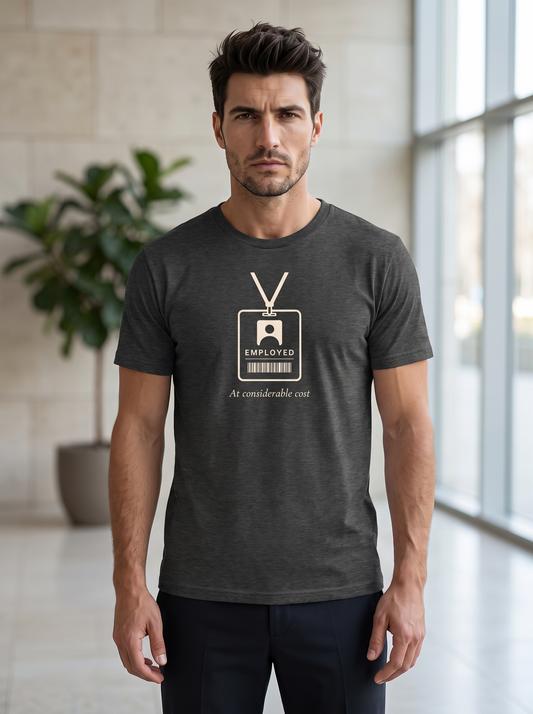 Liora wearing the unisex t-shirt in dark grey heather with a drawing of a staff badge on a lanyard reading employed and serif type reading at considerable cost. Model: Liora (AI brand character). AI-generated model image; the printed design is the actual product artwork.