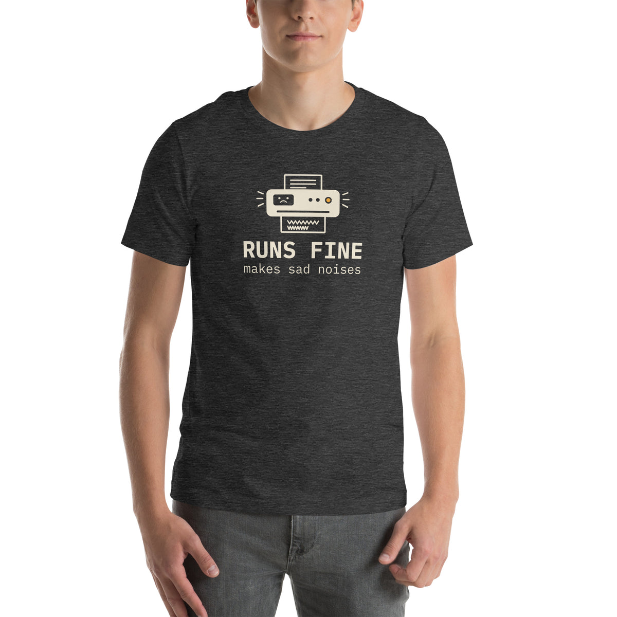 Unisex t-shirt in dark grey heather with a drawing of an office printer with a sad face display and monospace type reading runs fine, makes sad noises