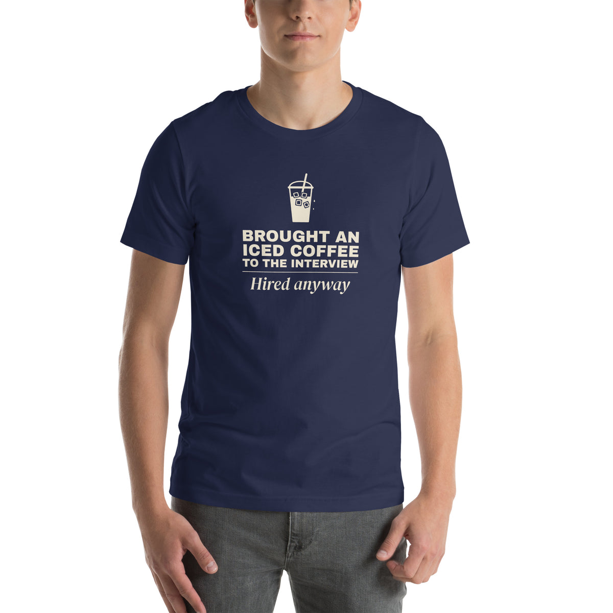 Unisex t-shirt in navy with a drawing of an iced coffee cup and cream bold type reading brought an iced coffee to the interview, hired anyway